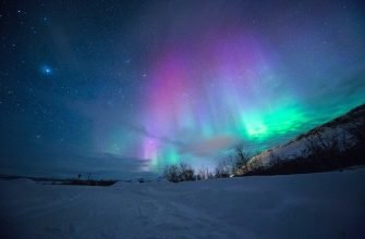 Северное сияние над снежным пейзажем в Мурманской области